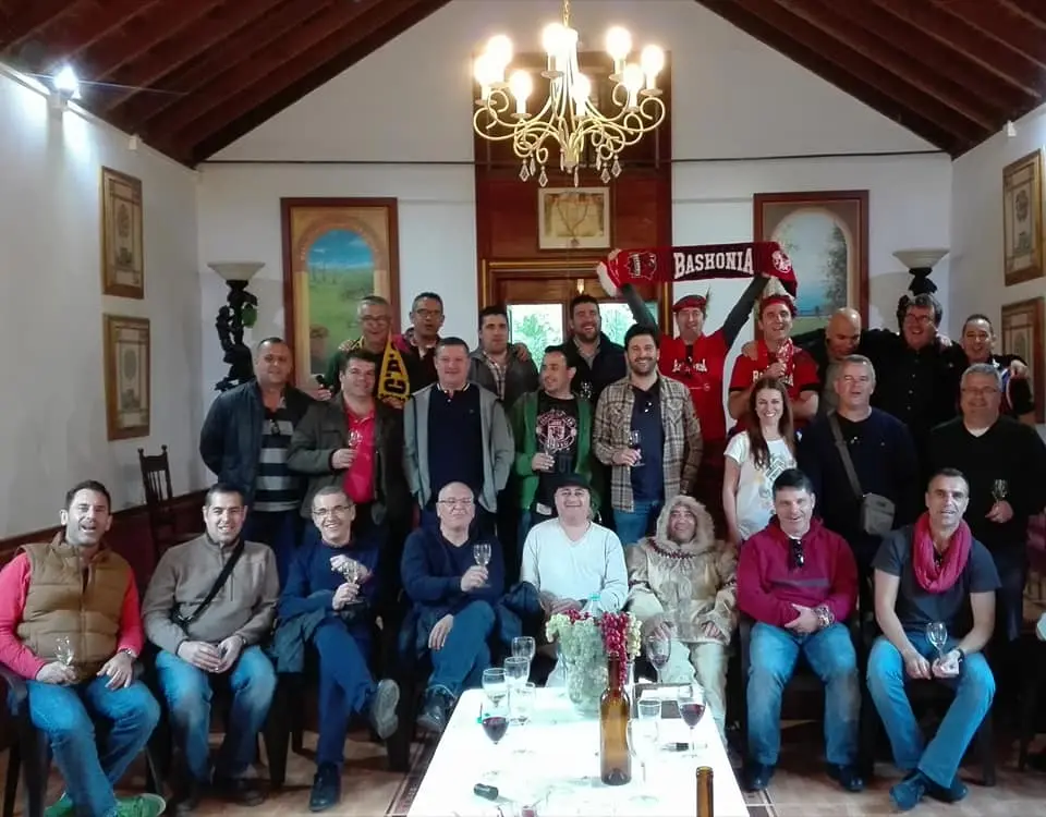 Visitantes junto a una de las prensas históricas de la bodega